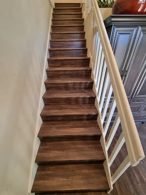 Dark wood staircase with white railing